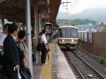 Serie 221: Am nassen und stickigen Morgen des 18.Juni 2011 wollen sich viele Menschen in den Zug drängen, um von Rokujizô nach Kyoto zur Arbeit zu fahren.