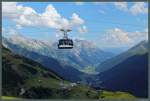 Eine Gondel der Vallugabahn bewegt sich am 09.08.2015 vor der eindrucksvollen Kulisse der Lechtaler Alpen von der Talstation auf dem Galzig bei St.