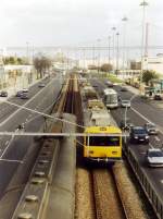 LISBOA (Distrikt Lisboa), 24.01.2001, rechts ein Vorortzug der Linha Cascais der Ausfahrt in den Bahnhof Belém, links ein Zug bei der Ausfahrt (Bahn-Linksverkehr in Portugal); im Hintergrund die