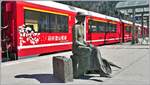 Die Wartende sitzt nicht in Japan, sondern in Thusis, wo die japanischen Schriftzeichen auf dem neuen Alvrawagen auf die Partnerbahn der RhB, der Hakone Tozan Railway, hinweisen.