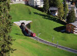 Regionalzug von Arosa nach Chur verlässt soeben den Tunnel beim Bahnhof Arosa und fährt talwärts Richtung Chur.