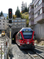 Der Regionalzug von Chur hat den Tunnel kurz vor Arosa verlassen und fährt in den Bahnhof ein.