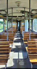 Schmalspurbahn Balatonfenyves (HU)  Blick in das Innere eines Personenwagens der Balatonfenyveser Kleinbahn, bestehend aus Holzbänken, Fenster zum Öffnen und einem Ofen zum Heizen.